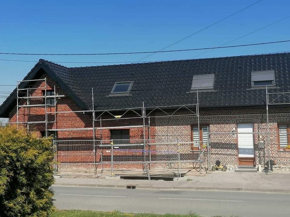 Pose de tuiles en terre cuite sur une toiture en France